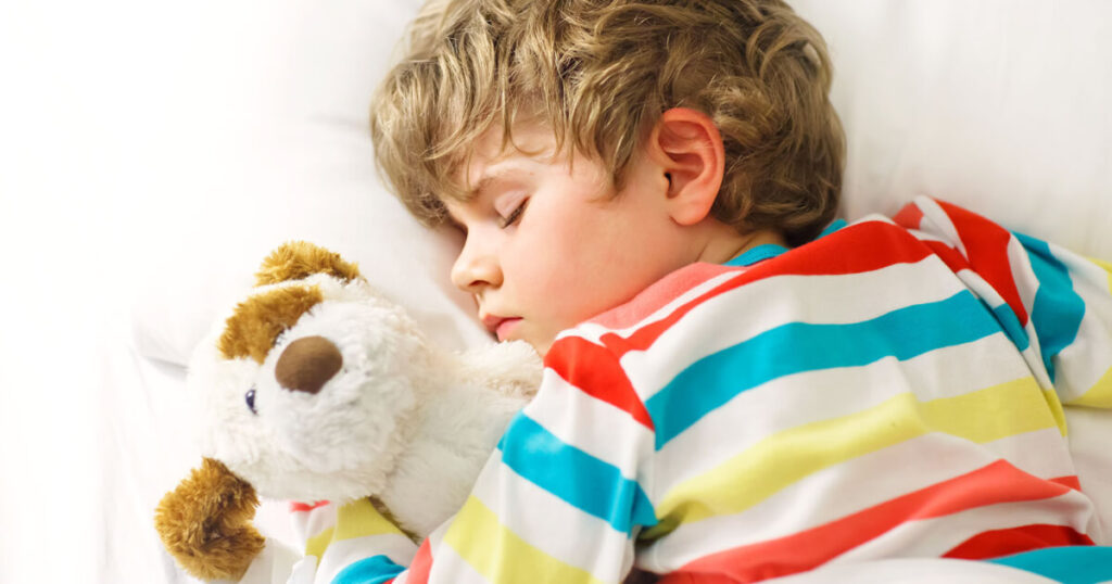 manage bedtime, a boy sleeping with a teddy bear.