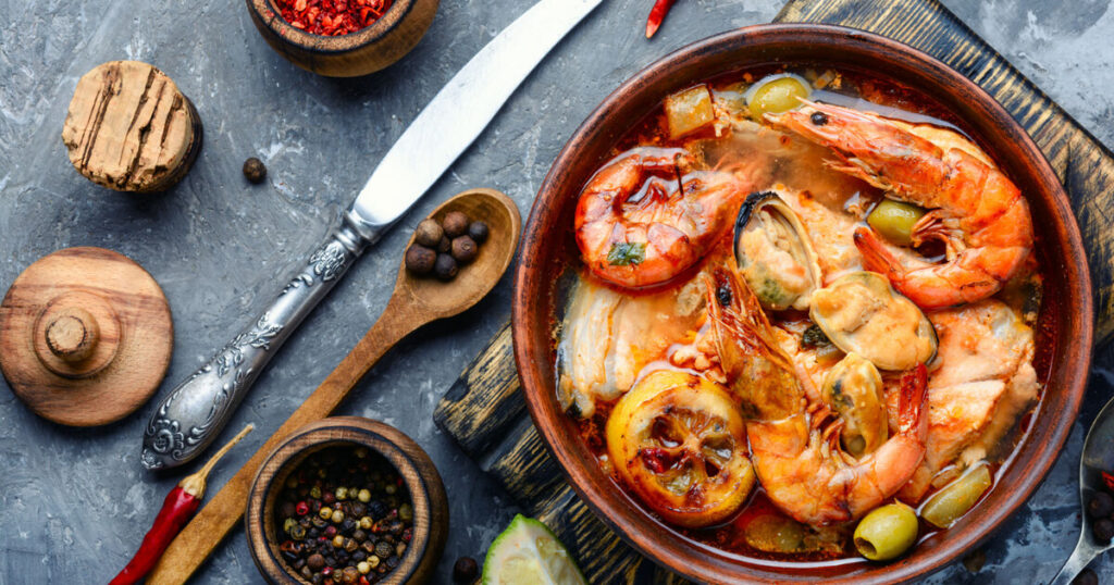 a bowl with seafoods, wooden spoon, spices.