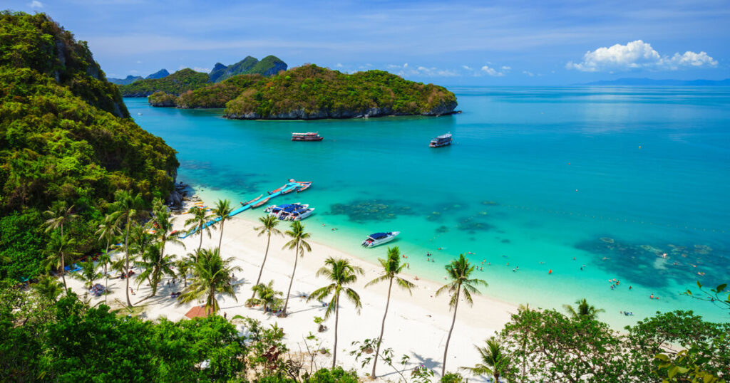 amazing beach in Thailand, coconut trees, mountains, boat, ferry, crowd on beach, best places to visit in Thailand.