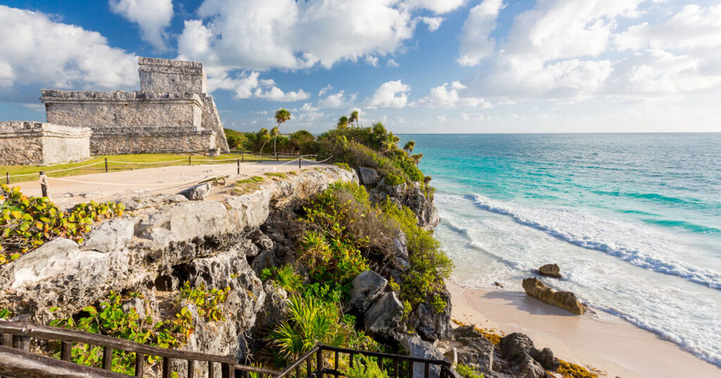 Tulum beach, El Castillo, blue water, lush green.