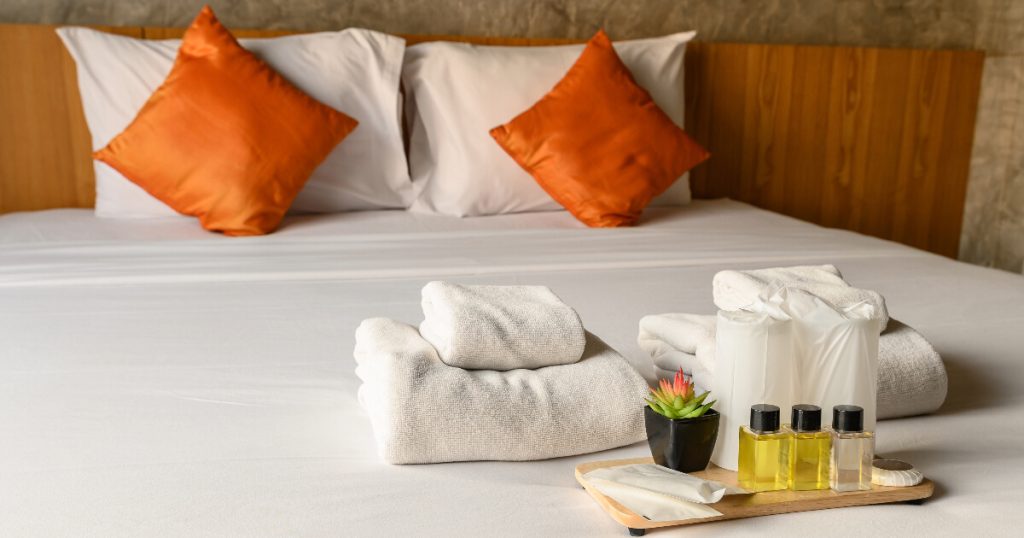 Italian hotels, orange pillows, white towels in hotel, wooden bed.